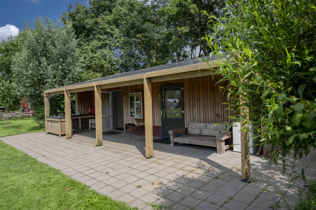 The sanitary building with covered walkway and bench