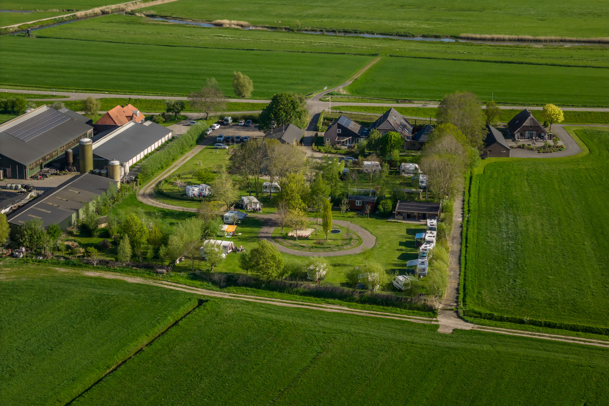 Luchtfoto van Boerderij de IJsselhoeve tussen de weilanden